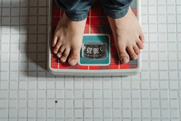 woman standing on old style scales