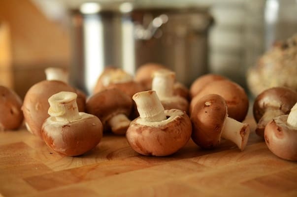 Bunch of button mushrooms on a chopping block