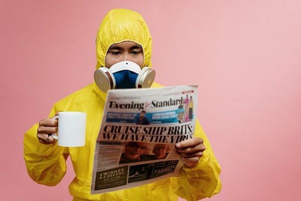 man in hazmat suit reading the paper