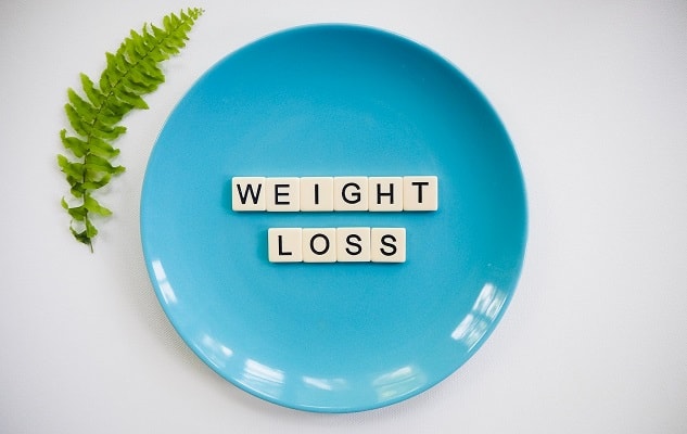 Blue plate with weight loss spelled in scrabble letters