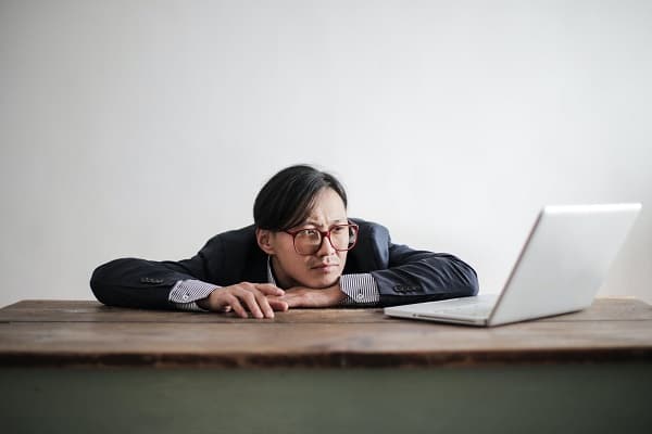 Man looking sadly at a laptop computer