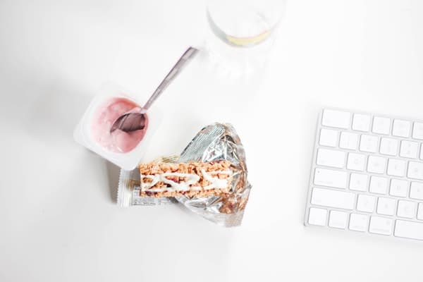 tub of strawberry yogurt open on a work desk