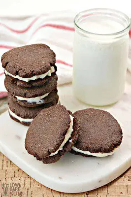 Gluten free oreo cookies on a plate next to glass of milk