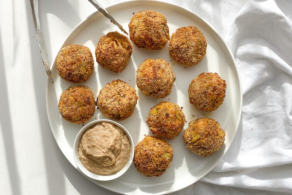 keto broccoli balls with cottage cheese and tahini dip on a white plate