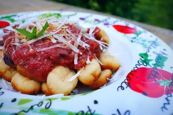 keto ricotta & tomato gnocchi on a colorful plate topped with cheese