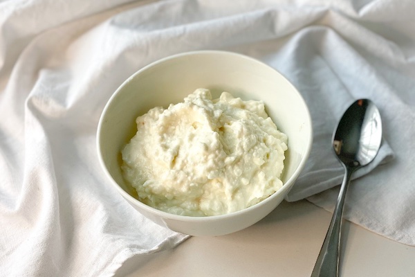 keto whipped cottage cheese dessert in a white bowl with silver spoon