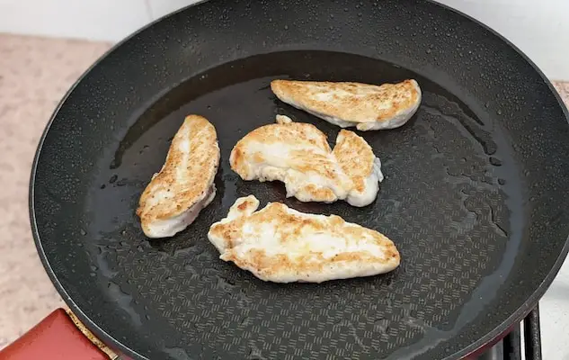 chicken tenders browning on hot non-stick pan