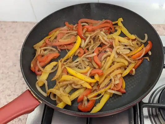 Peppers and onion sautéing in non-stick fry pan
