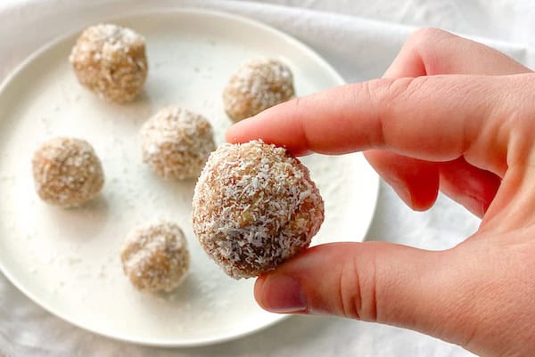 hand holding a delicious vegan coconut bliss ball