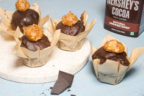 Vegan keto chocolate cupcakes nicely presented on a blue bench