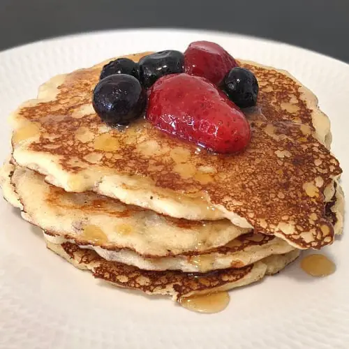 keto cottage cheese pancakes with berries and syrup on top