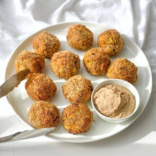 cottage cheese broccoli balls on a white plate next to tongs