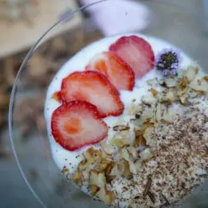 keto noatmeal with ricotta and cinnamon in a glass with strawberries for decoration