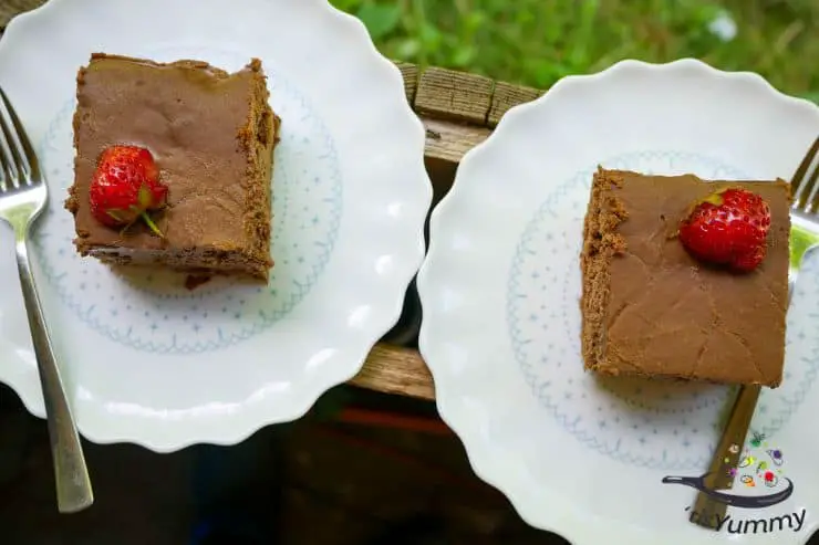 fluffy keto ricotta brownies on white plates with strawberries on top