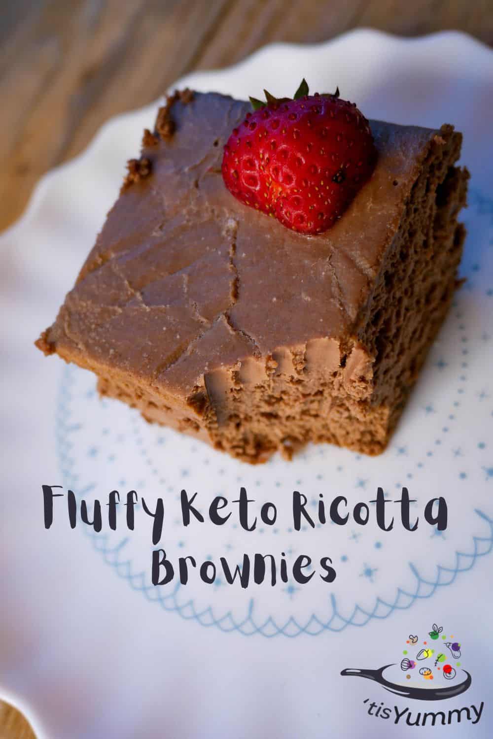 Fluffy keto ricotta brownies on a white plate with a strawberry on top