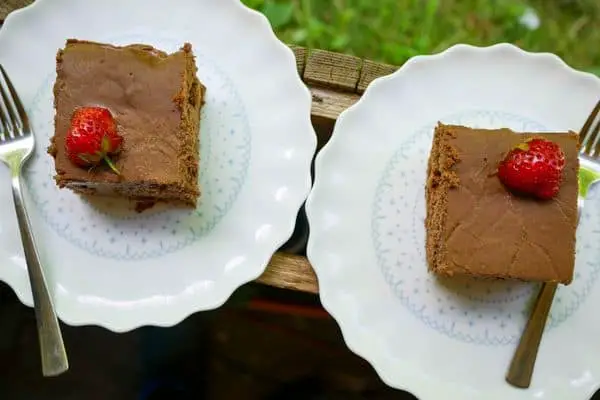 keto ricotta brownies on white plates with forks and strawberries on top