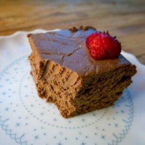 keto brownie in a plate with a strawberry on top and bite taken out