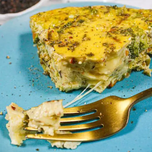 Keto vegetable frittata on a blue plate with gold fork