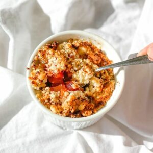 keto strawberry and rhubarb crumble in a white bowl